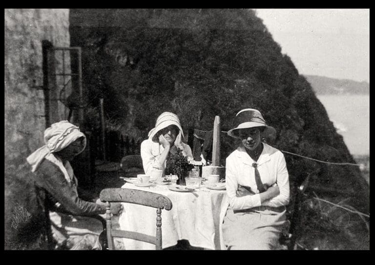 Three woman sat a table having tea outside the cabin